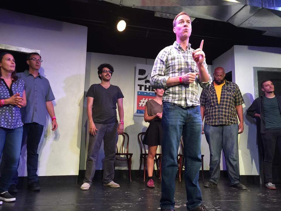 Patrick McInnis performing improv on stage with his ensemble